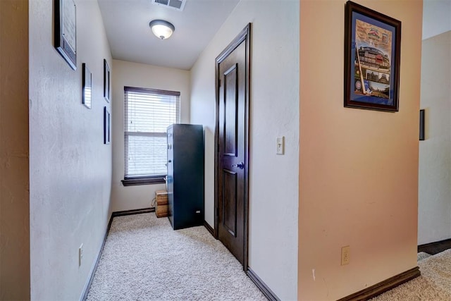 corridor featuring light colored carpet