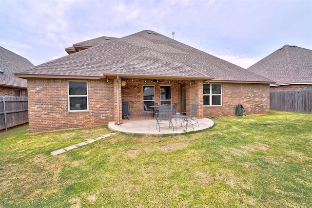 back of property with a lawn and a patio area