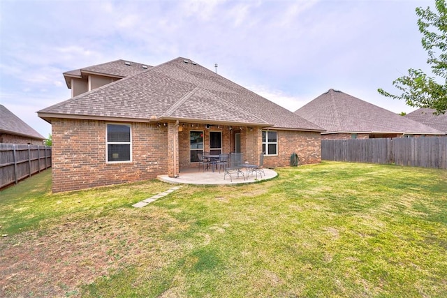 rear view of house featuring a lawn and a patio area