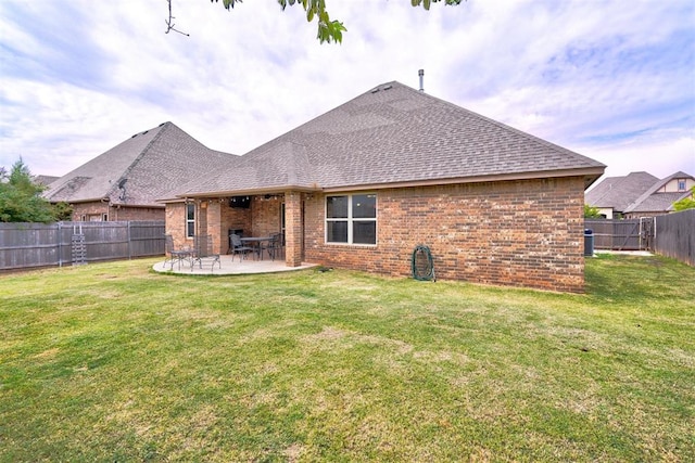 back of house with a yard and a patio