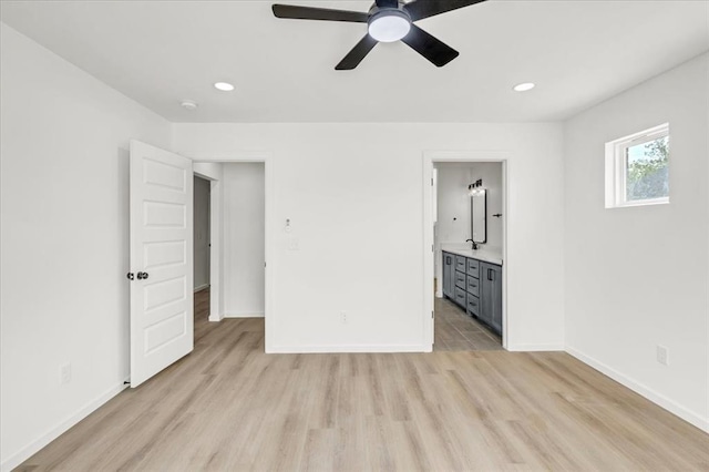 unfurnished bedroom with ensuite bathroom, ceiling fan, sink, and light hardwood / wood-style flooring