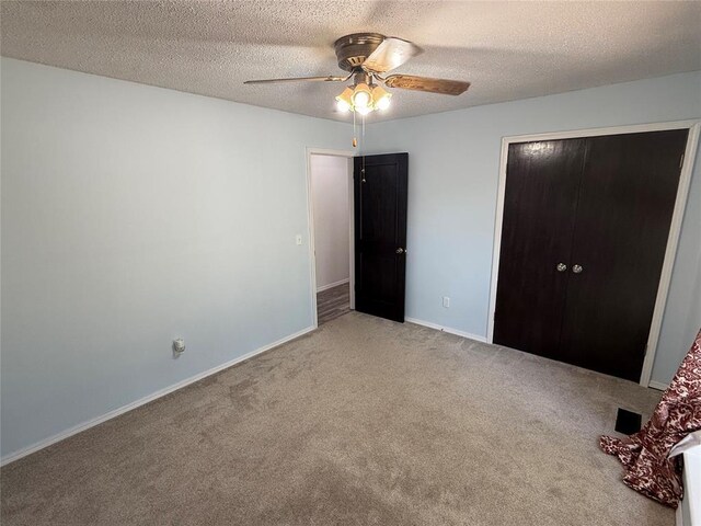 unfurnished bedroom with ceiling fan, carpet floors, a closet, and a textured ceiling