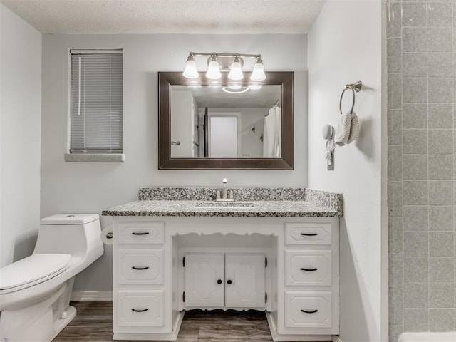 bathroom featuring hardwood / wood-style flooring, vanity, a textured ceiling, and toilet