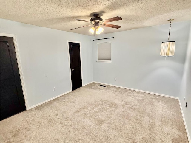 unfurnished room with ceiling fan, carpet flooring, and a textured ceiling