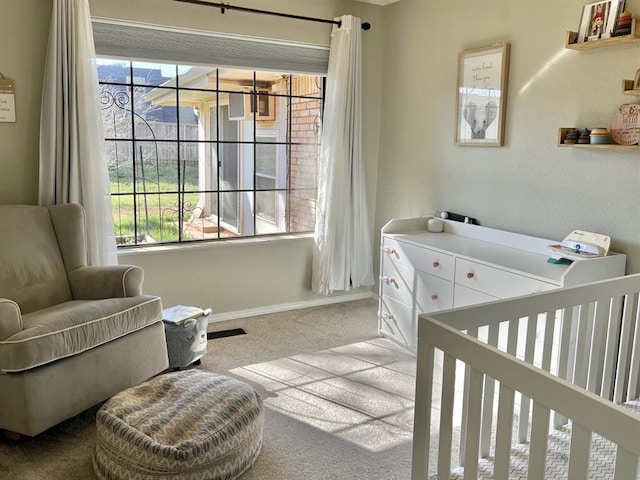 bedroom with light carpet and a nursery area