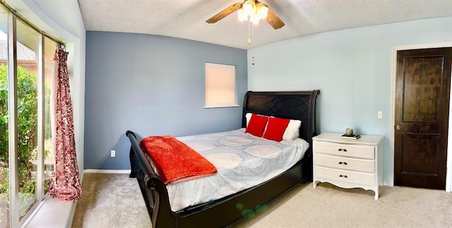 carpeted bedroom featuring ceiling fan and a textured ceiling