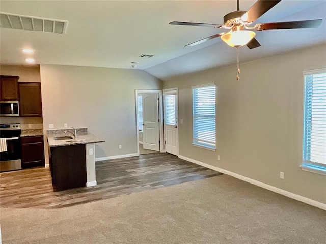 kitchen featuring ceiling fan, carpet floors, lofted ceiling, dark brown cabinets, and appliances with stainless steel finishes