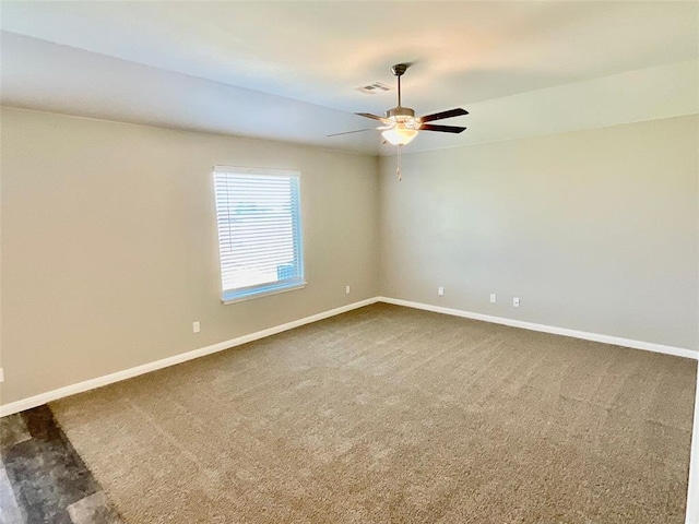 carpeted spare room featuring ceiling fan