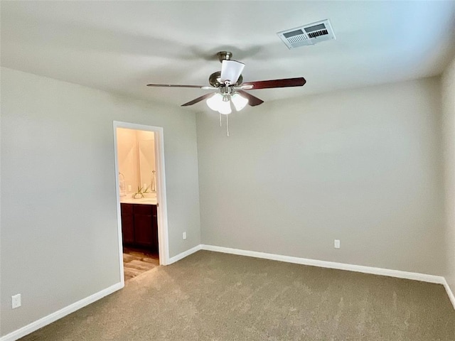 unfurnished bedroom with carpet, ceiling fan, and ensuite bath