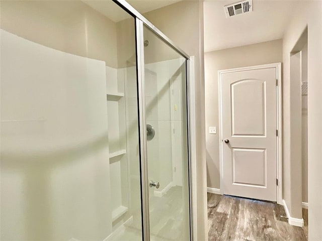 bathroom featuring hardwood / wood-style flooring and a shower with shower door