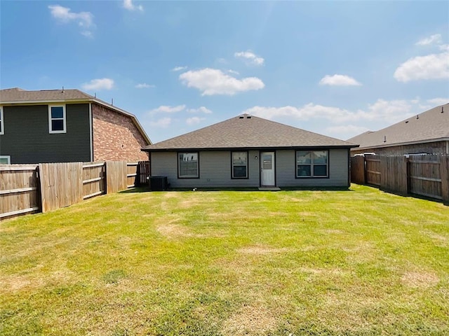 rear view of property featuring a yard and central AC