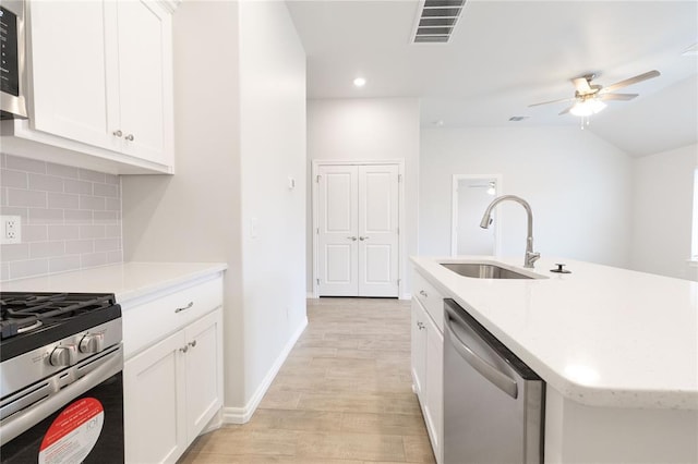 kitchen with a sink, light countertops, ceiling fan, and appliances with stainless steel finishes