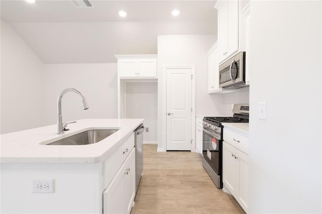 kitchen featuring white cabinets, a sink, an island with sink, recessed lighting, and stainless steel appliances