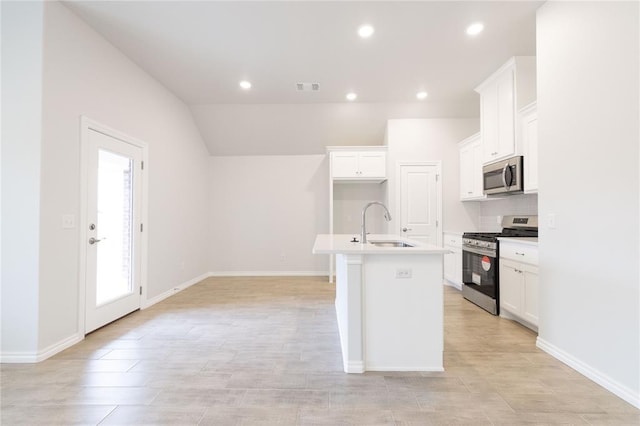 kitchen with white cabinetry, a kitchen island with sink, visible vents, appliances with stainless steel finishes, and a sink