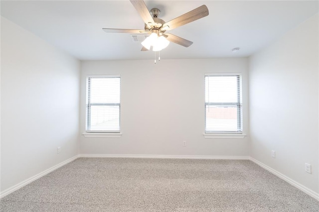 carpeted empty room with ceiling fan and baseboards