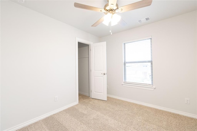 unfurnished room with visible vents, baseboards, ceiling fan, and light carpet
