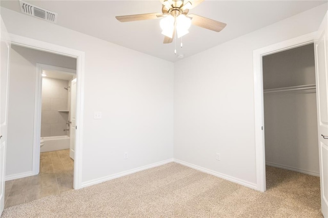 unfurnished bedroom featuring a closet, light colored carpet, baseboards, and visible vents