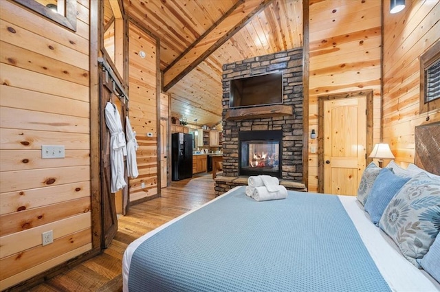 bedroom featuring black refrigerator, wooden walls, vaulted ceiling, hardwood / wood-style flooring, and wood ceiling