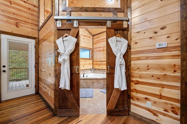 mudroom with wooden walls and wood-type flooring