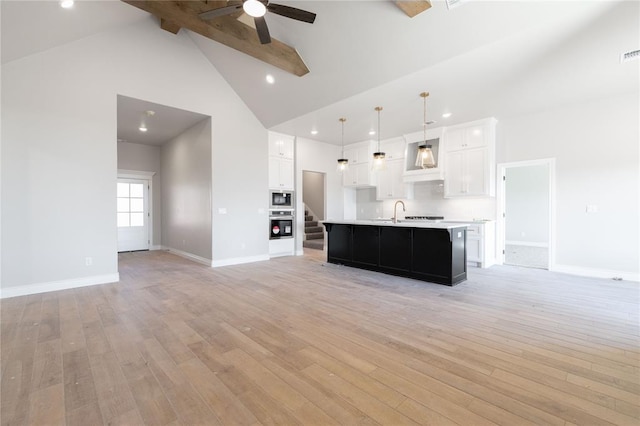 unfurnished living room with baseboards, a ceiling fan, stairs, light wood-style floors, and high vaulted ceiling