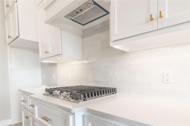 kitchen with backsplash, white cabinets, and light countertops