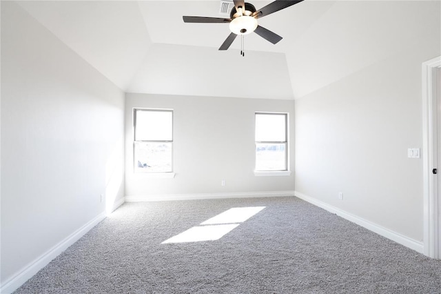 spare room with a ceiling fan, carpet flooring, vaulted ceiling, and baseboards