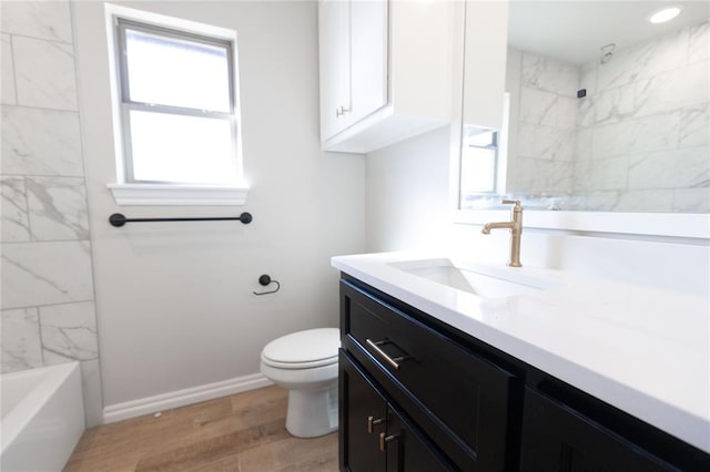 bathroom with toilet, recessed lighting, wood finished floors, vanity, and baseboards