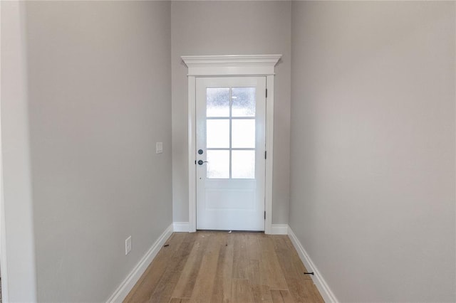 doorway featuring light wood-style flooring and baseboards