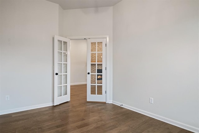 spare room with french doors and dark wood-type flooring