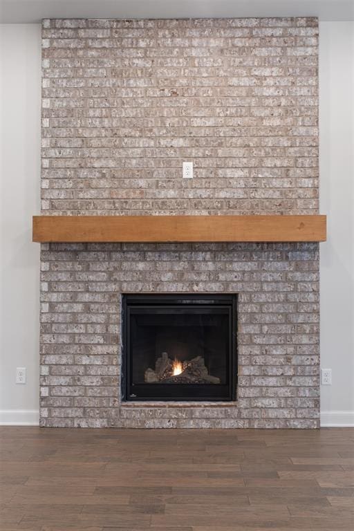 details featuring hardwood / wood-style floors and a brick fireplace