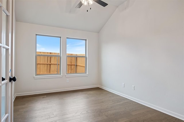 unfurnished room featuring vaulted ceiling, ceiling fan, and dark hardwood / wood-style floors