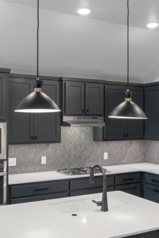 590 Emmy Jean Dr, Blanchard, OK 73010 - kitchen with light countertops, under cabinet range hood, pendant lighting, and tasteful backsplash