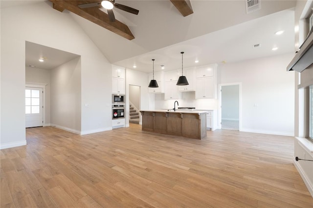 kitchen featuring stainless steel appliances, open floor plan, visible vents, and light wood-style flooring