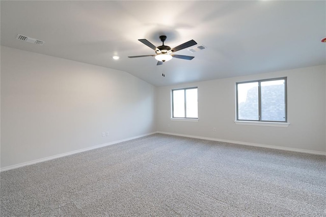 empty room with visible vents, vaulted ceiling, and baseboards