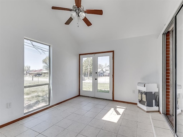 tiled empty room featuring ceiling fan, french doors, and lofted ceiling