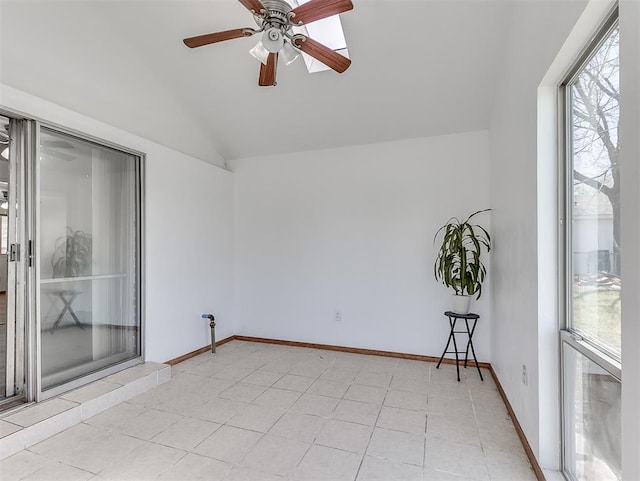 empty room with vaulted ceiling, ceiling fan, and light tile patterned flooring