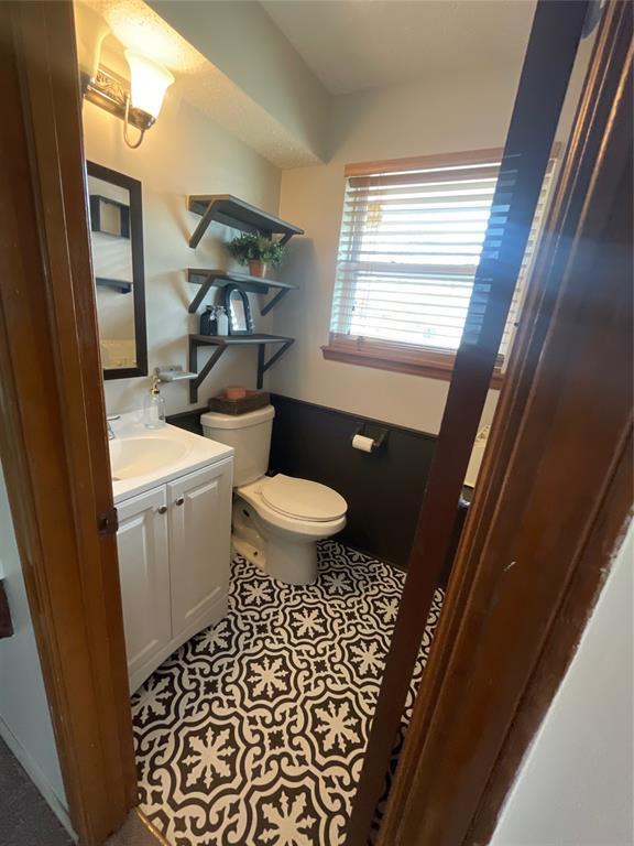 bathroom with toilet, tile patterned floors, and vanity