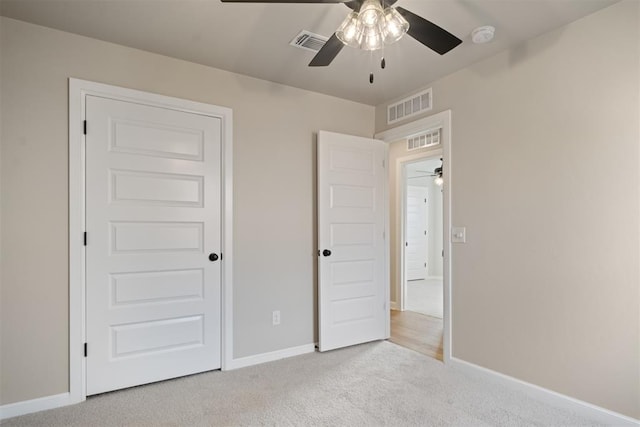 unfurnished bedroom featuring light carpet, a closet, and ceiling fan