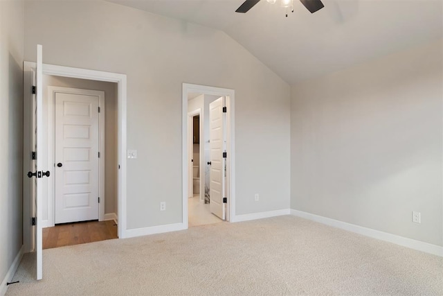 unfurnished bedroom with carpet, ensuite bath, vaulted ceiling, and ceiling fan