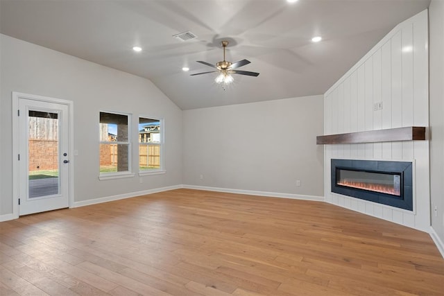 unfurnished living room with ceiling fan, light wood-type flooring, a fireplace, and vaulted ceiling