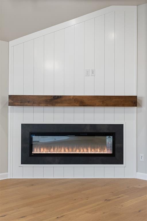 interior details featuring hardwood / wood-style floors and a large fireplace