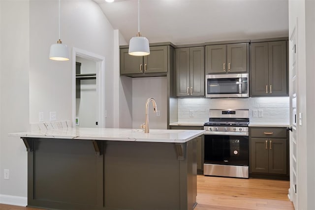 kitchen with kitchen peninsula, a kitchen breakfast bar, stainless steel appliances, and hanging light fixtures