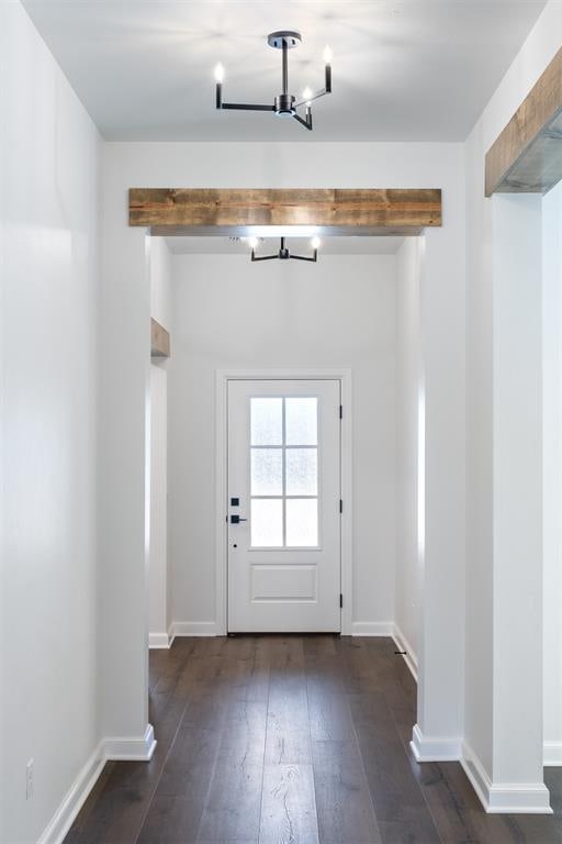 doorway with dark hardwood / wood-style flooring and a notable chandelier