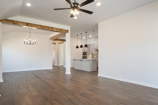 unfurnished living room featuring ceiling fan with notable chandelier, dark hardwood / wood-style floors, and vaulted ceiling