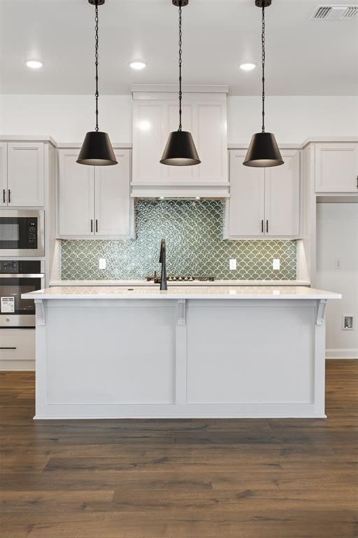 kitchen featuring white cabinetry, pendant lighting, stainless steel appliances, and dark hardwood / wood-style floors