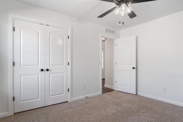 unfurnished bedroom with ceiling fan, carpet floors, and a closet