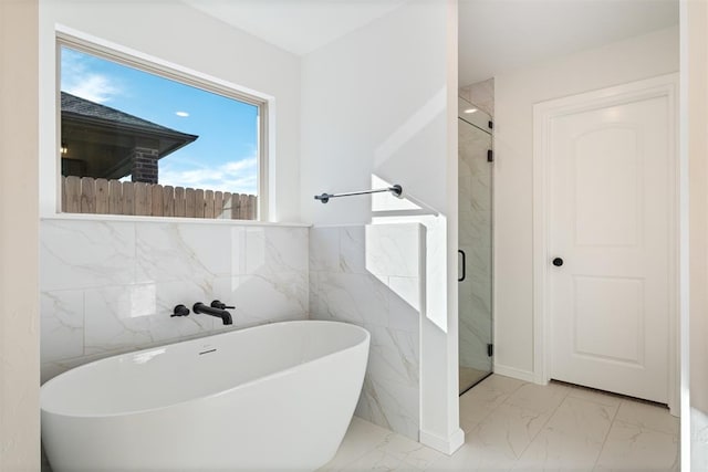 bathroom with tile walls and independent shower and bath