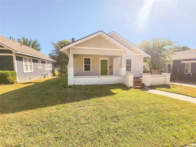 bungalow-style home with a front yard and covered porch