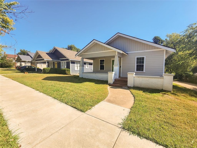 view of front of property featuring a carport, a porch, and a front lawn