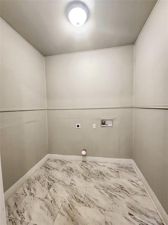 laundry area featuring wooden walls, washer hookup, and hookup for an electric dryer